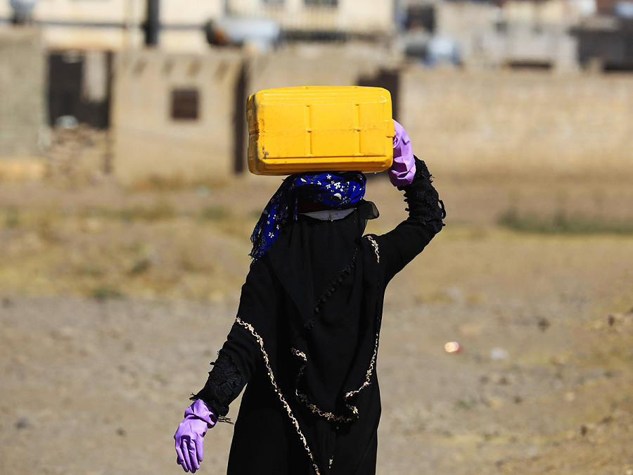 Sana’a (Yemen). Una donna trasporta una tanica dopo averla riempita da un serbatoio. In Yemen, uno dei Paesi pi&ugrave; carenti d’acqua al mondo, donne e bambini spesso sono responsabili dell’approvvigionamento idrico per le loro famiglie. Secondo le stime dell&rsquo;Onu, quasi 15,4 milioni di persone sui 30 milioni di abitanti del Paese non hanno accesso all’acqua potabile. Le condizioni della popolazione sono aggravate da oltre 9 anni di conflitto e siccit&agrave;. 
