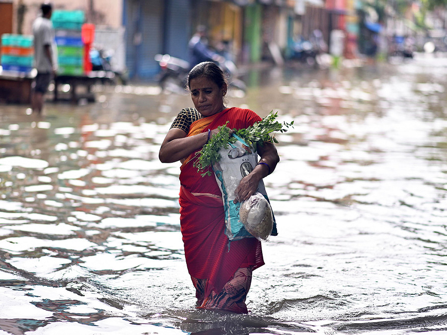 Chennai, India. Una donna cammina in una strada allagata a seguito di forti piogge. Il Dipartimento meteorologico indiano (IMD) ha emesso un’allerta arancione per piogge da forti a molto forti nel Tamil Nadu, Puducherry e Karaikal per il 2 e il 3 dicembre a causa della formazione di un’area di bassa pressione nel Mare delle Andamane meridionali e nelle aree adiacenti. Credit: EPA/IDREES MOHAMMED