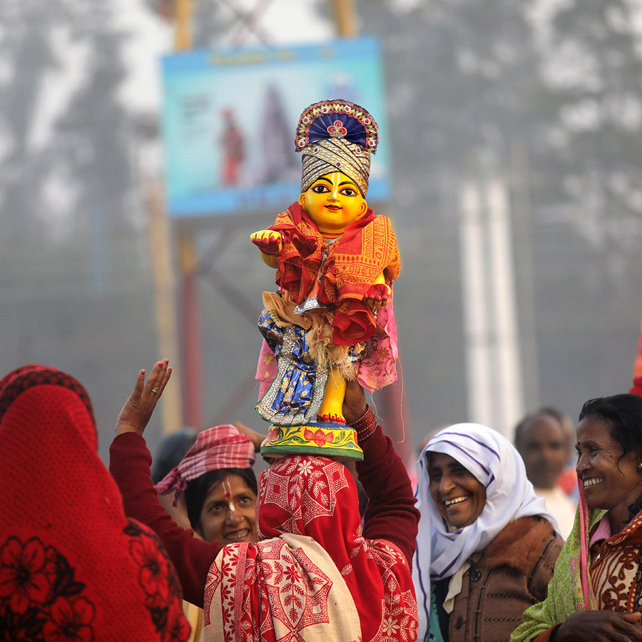 Sagar (India). Una donna porta sulle spalle una statua del Dio Krishna mentre esegue una danza sacra durante la fiera annuale di Ganga Sagar. I pellegrini ind&ugrave; si radunano in occasione del Makar Sankranti per fare un tuffo nel Gange prima che confluisca nel Golfo del Bengala.