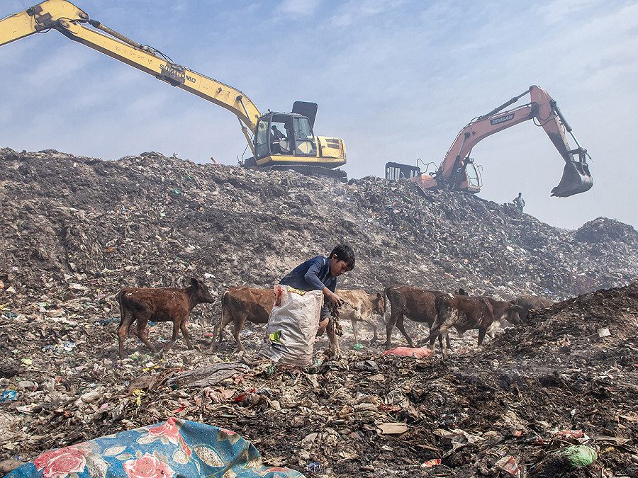 Chittagong (Bangladesh). Alcuni bambini mentre lavorano nella discarica  di Chittagong a Halishahar. Raccolgono materiali riciclabili dai cumuli di rifiuti e li portano nei negozi di rottami. 