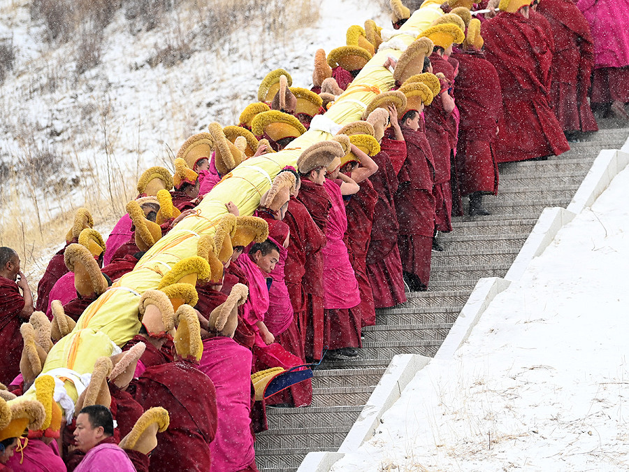 Labrang (Cina). Monaci portano sulle spalle un enorme dipinto Thangka durante la cerimonia annuale dell’esposizione del Buddha. Pi&ugrave; di 40.000 credenti e turisti hanno partecipato al grande evento buddista tibetano nel monastero di Labrang, uno dei 6 grandi templi della setta Gelug.