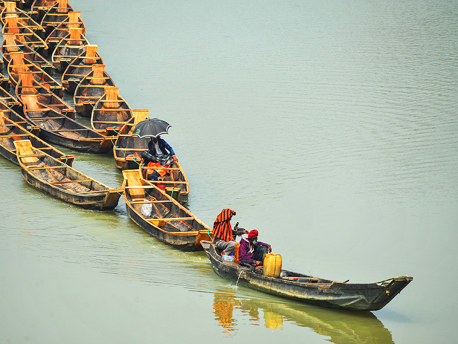 Sylhet (Bangladesh). I commercianti stanno legando insieme un centinaio di barche di legno sul fiume Chengerkhal. La richiesta per queste particolari imbarcazioni &egrave; aumentata in vista della stagione dei monsoni. 