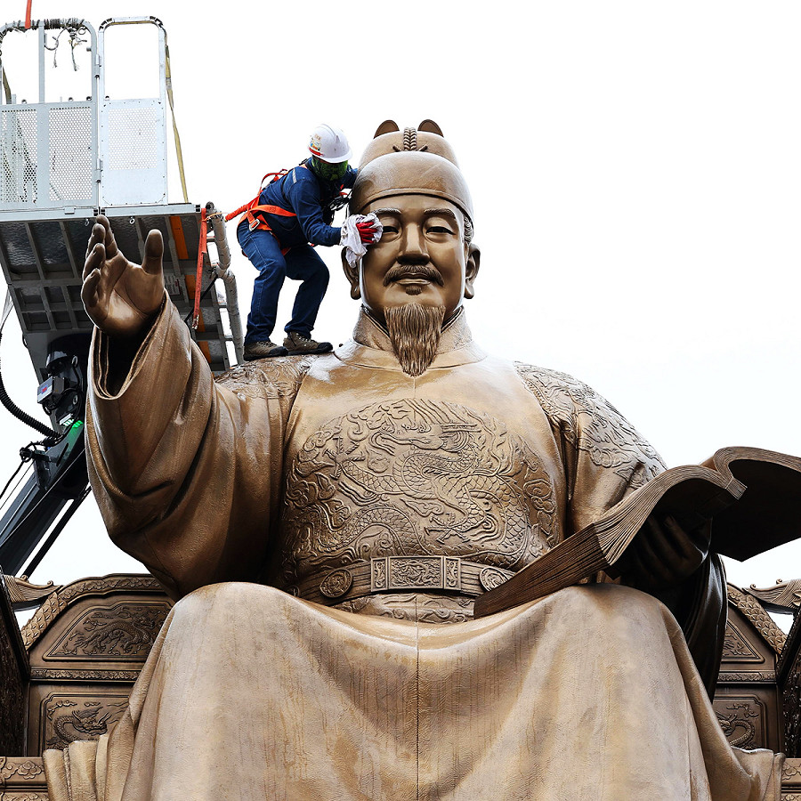 Seoul (Corea del Sud). Un operaio pulisce la statua del re Sejong in piazza Gwanghwamun nel centro di Seoul