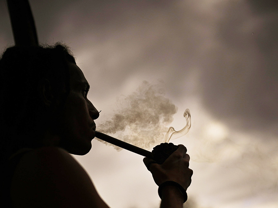 Brasilia (Brasile). Un uomo indigeno fuma durante il Free Land Camp, il raduno annuale in cui si riuniscono migliaia di persone in segno di protesta per i diritti territoriali e culturali dei popoli nativi.