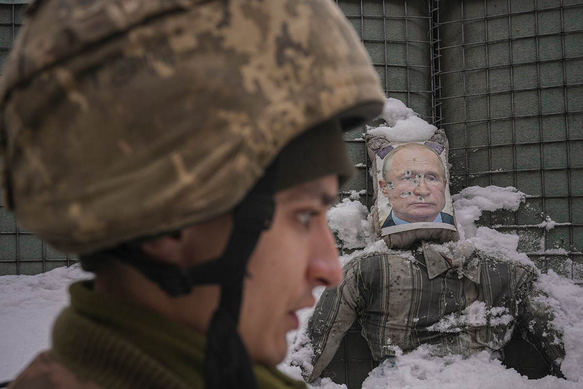 Un militare ucraino vicino una effige distrutta raffigurante Putin