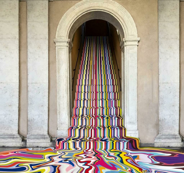 Colata di vernice multicolore lungo la scalinata che collega il pianterreno al primo piano. “L’arte è incontrollabile, ingestibile; non resta che lasciarsi contaminare e sorprendere” (Ian Davenport, Poured staircase, 2022).