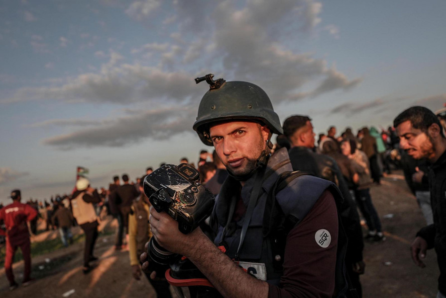 Il fotografo palestinese Moahmmed Asad mostra la telecamera distrutta durante uno scontro a fuoco al confine tra Israele e la striscia di Gaza (EPA/MOHAMMED SABER)