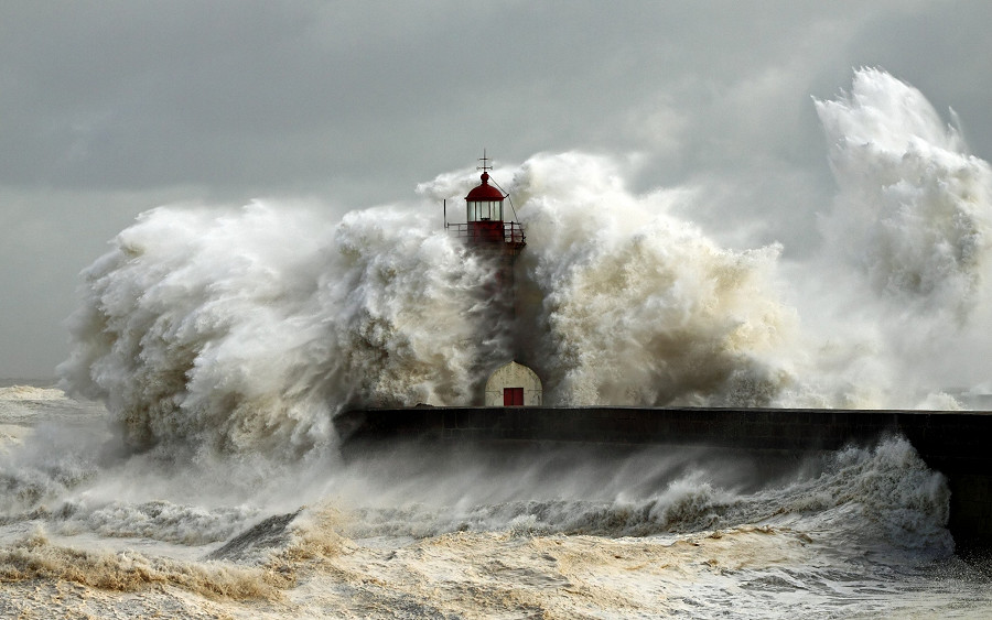 Porto (Portogallo). Il Farol de Felgueiras, alto 10 metri, è a malapena visibile mentre il mare in tempesta lo sovrasta. Non è insolito che onde di queste dimensioni si infrangano sui litorali portoghesi, spesso colpiti dalle perturbazioni atlantiche. (UNSPLASH) 
