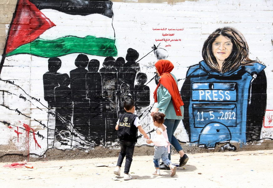 Alcuni palestinesi camminano davanti a un murale dedicato alla giornalista di Al Jazeera Shireen Abu Akleh nella città cisgiordana di Betlemme 