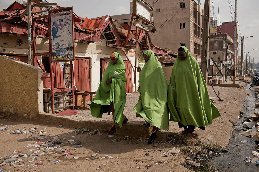Donne musulmane nigeriane camminano tra le macerie della città di Kaduna, devastata dalle bombe nell'aprile 2012