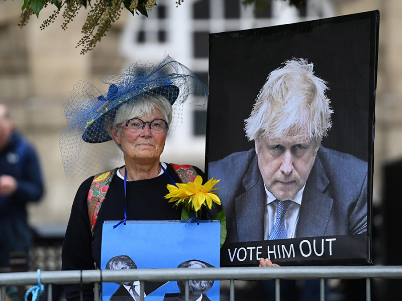 Una signora protesta, all'esterno del Parlamento inglese, contro le politiche del primo ministro Boris Johnson
