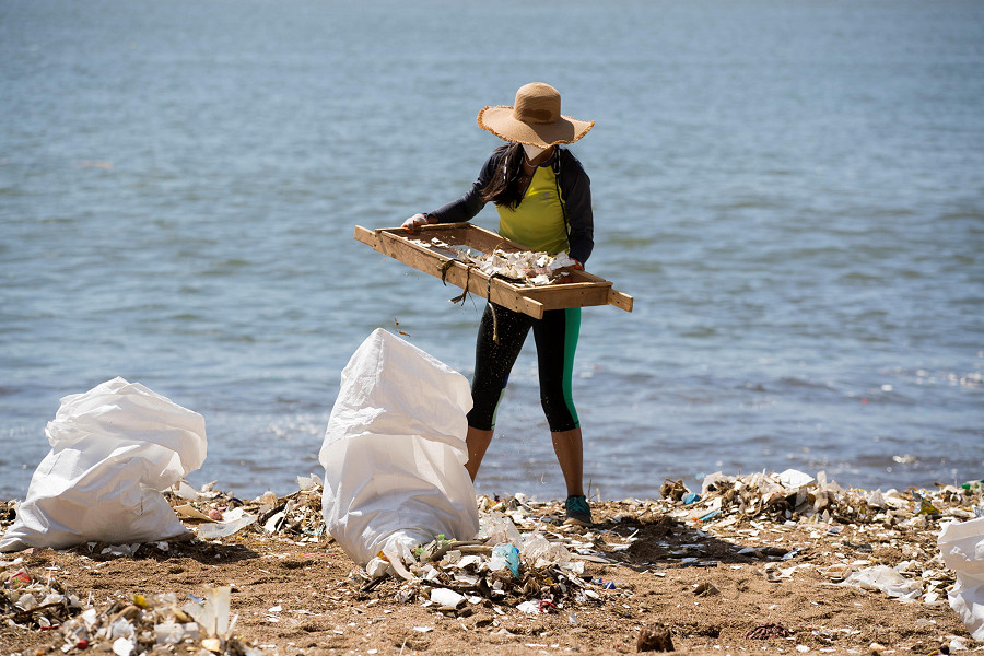 Una volontaria dominicana pulisce una spiaggia di Fuerte San Gil durante il World Beach Cleaning Day.