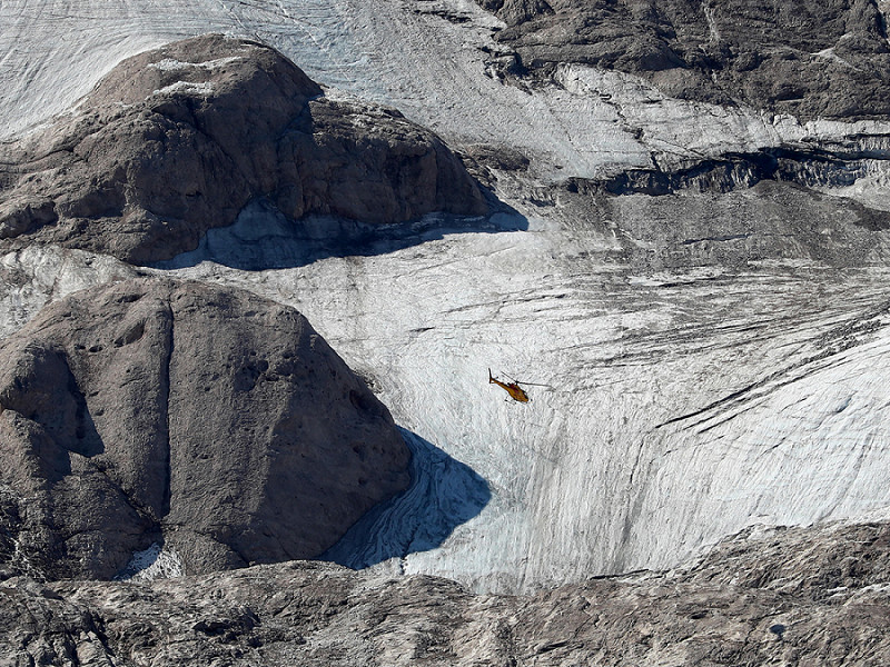 Un elicottero sorvola la zona della valanga per cercare le persone ancora disperse sul ghiacciaio della Marmolada a Canazei, il 04 luglio 2022