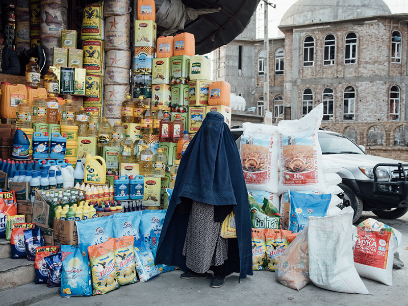 Una donna afghana all'ingresso di un negozio di alimentari a Kabul nel 2021