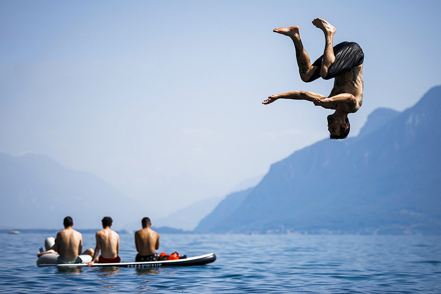 Un uomo mentre si butta nel lago di Ginevra, Svizzera, lo scorso giugno