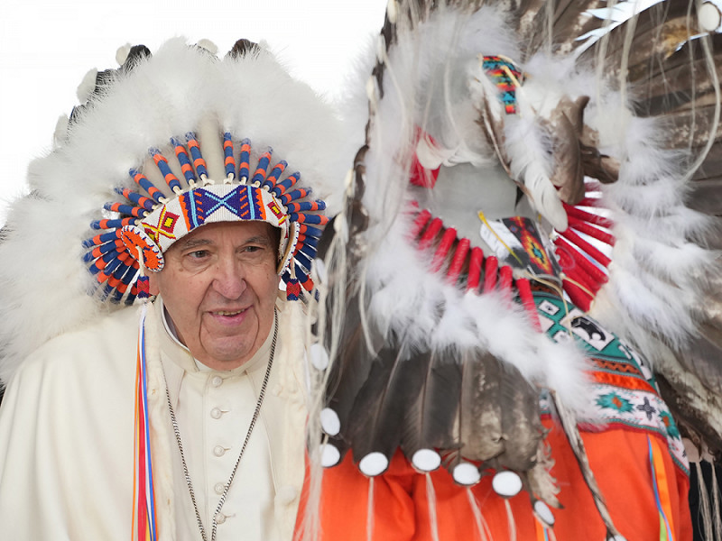 Papa Francesco indossa un copricapo tradizionale che gli è stato dato dopo le sue scuse alle popolazioni native durante una cerimonia a Maskwacis, parte della sua visita papale in tutto il Canada.