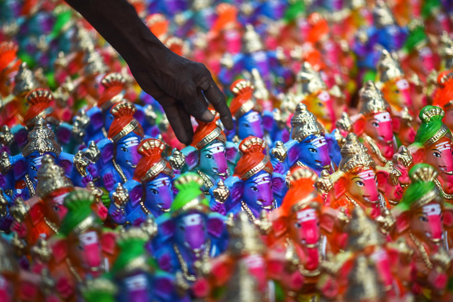 Chennai (India). Un artigiano sistema gli idoli del dio indù con la testa di elefante Lord Ganesh, prima di portarli al mercato in occasione del festival di Ganesh Chaturthi. Questo è uno dei più grandi eventi indù in onore del dio Ganesha e ha una durata di dieci giorni in tutta l'India. Durante il festival, gli idoli di Ganesha vengono posti e adorati in santuari pubblici temporanei oppure nelle case. 