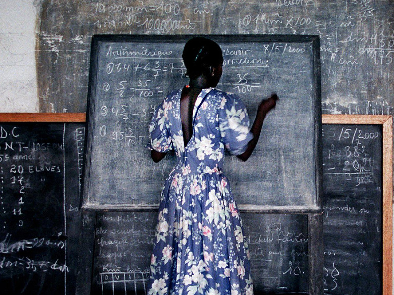 Une jeune fille termine un problème de mathématiques dans une école temporaire dans un camp de réfugiés du gouvernement à Kinshasa, Congo