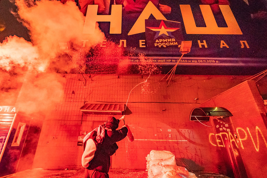 Kiev. Un manifestante getta vernice su uno striscione del canale televisivo NASH nella sua sede. I manifestanti vogliono la chiusura del canale televisivo, accusato di fare propaganda russa. 