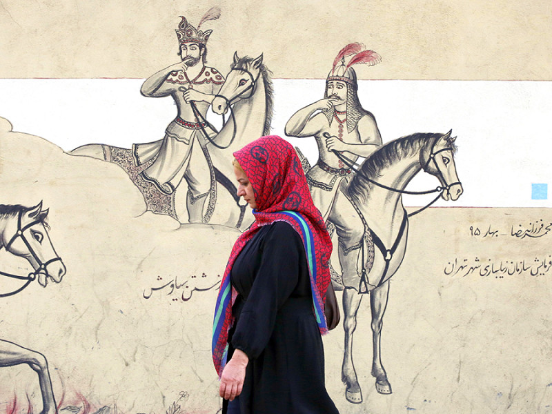 Una donna iraniana passa davanti a un murale di Teheran, il 10 ottobre 2022.