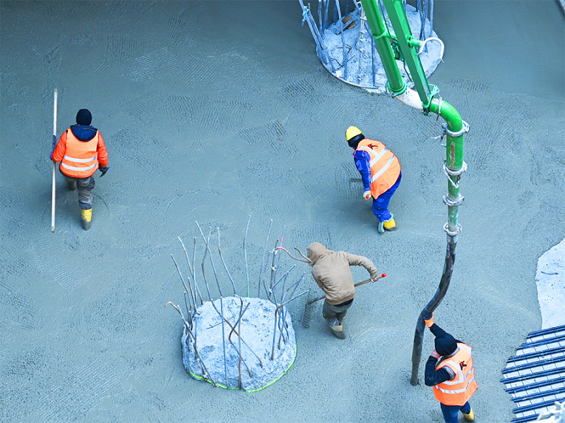 Lavoratori edili versano calcestruzzo per le linee geotermiche sotterranee per il progetto "Four", in Germania nel 2020