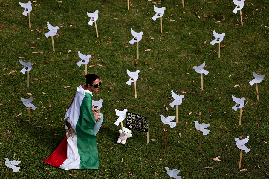 Sydney (Australia). Una donna indossa la bandiera iraniana tra le colombe di carta al Bicentennial Park durante una manifestazione di solidarietà alle proteste del popolo iraniano contro il regime.