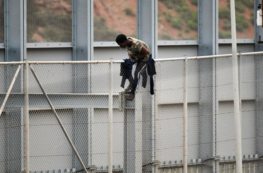 Un migrant saute la clôture entre le Maroc et Ceuta, enclave espagnole au nord de l'Afrique, le 13 avril 2021.