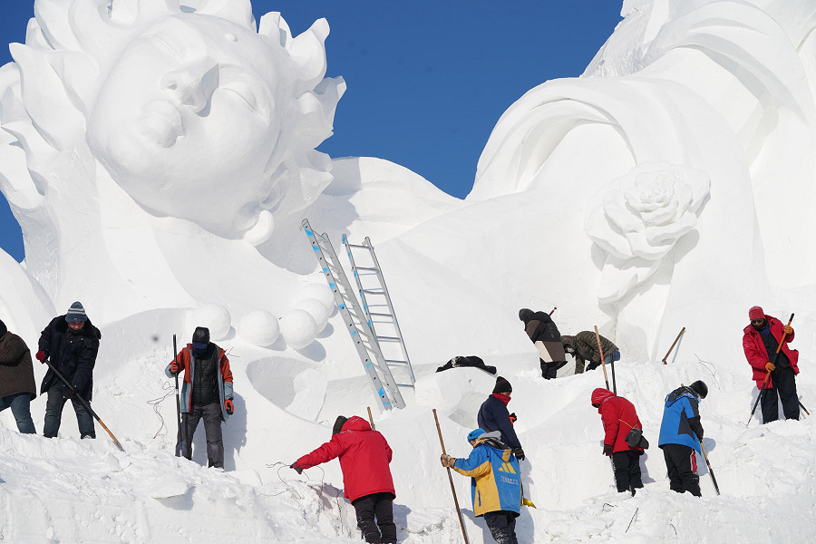 Harbin (Cina). I membri dello staff lavorano su una gigantesca scultura di neve per la 35° edizione dell'International Snow Sculpture Art Expo che sarà inaugurata ufficialmente il 5 gennaio presso l'area panoramica di Sun Island nella provincia di Heilongjiang.