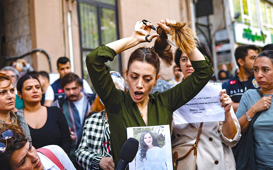 Il 21 settembre Nasibe Samsaei, una donna iraniana si taglia la coda di cavallo durante una protesta fuori dal consolato iraniano a Istanbul. Uno dei momenti più significativi degli oltre 100 giorni di proteste contro il regime di Teheran a seguito della morte di Masha Ameni il 13 settembre (AFP)