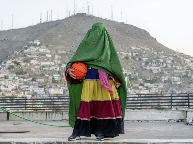 Kabul (Afghanistan). Una donna afghana posa con un pallone da basket. La foto fa parte di una serie di ritratti realizzati per denunciare la condizione femminile nel Paese, dove i talebani hanno bandito donne e ragazze dallo sport, dalle scuole secondarie e da parte delle attività lavorative.