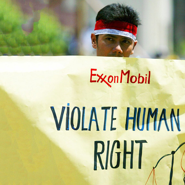 Un ex dipendente della ExxonMobil tiene un cartello durante una protesta a Giacarta, in Indonesia, il 22 novembre 2007. L'azienda è uno dei maggiori operatori di giacimenti di gas del Paese.