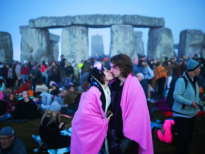 Amesbury (Regno Unito). Una coppia si bacia di fronte al sito di Stonehenge. 10.000 persone si sono date appuntamento per celebrare il solstizio d'estate all’interno del complesso preistorico composto da 93 pietre disposte a cerchio nel nord-ovest dell’Inghilterra. 