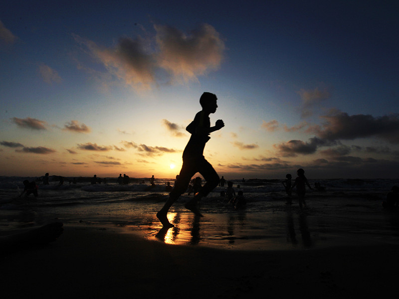 Gaza (Palestina). Un ragazzo corre sulla spiaggia. Per i palestinesi che vivono nell'affollata Striscia di Gaza, l'ondata di caldo estivo è peggiorata dalle interruzioni di corrente dovute al blocco israeliano in corso.