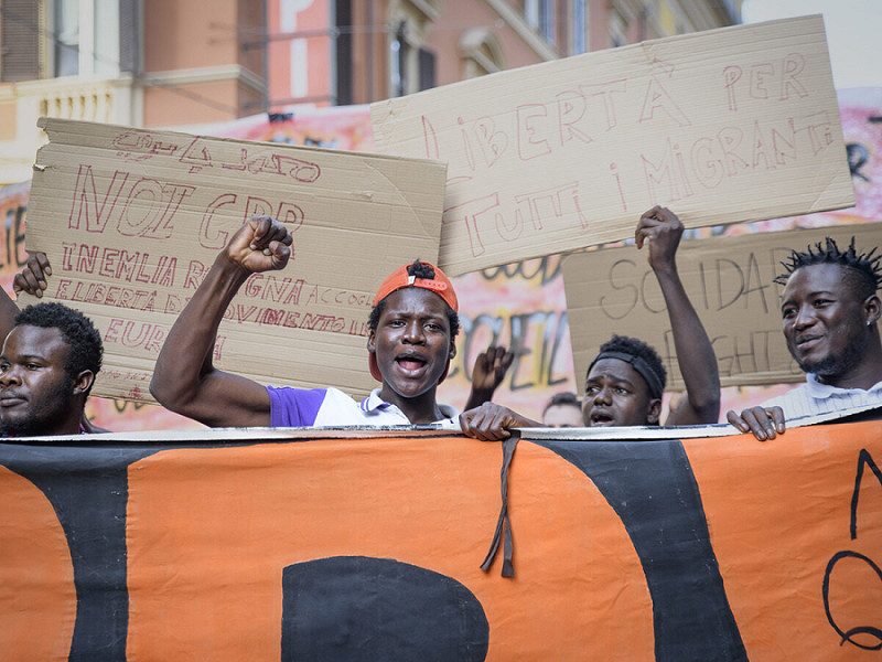 14 ottobre 2023, Bologna, Italia: Migranti protestano a braccia alzate durante la manifestazione contro i CPR a Bologna.&nbsp;
