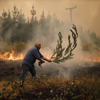 Santa Juana (Cile). Vigili del fuoco e residenti lavorano per spegnere un incendio. Sale a 15 il bilancio delle vittime dei roghi che hanno già distrutto più di 45.000 ettari nel centro e nel sud del Paese.